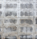 Professional installing outdoor floor tiles using VURA tile adhesive in suitable weather conditions.