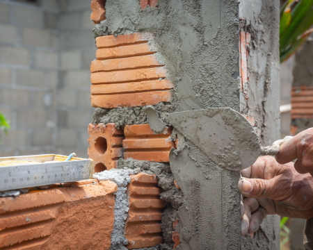 AAC block adhesive application during modern lightweight block wall construction