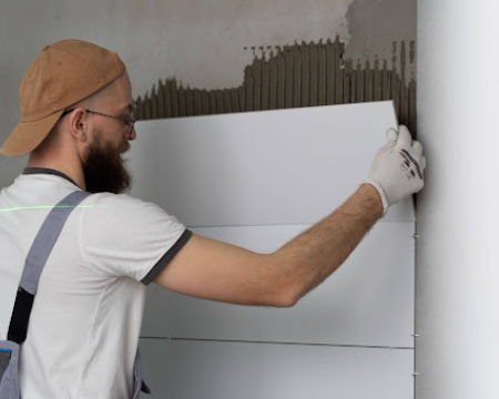 Professional installing ceramic floor tiles using VURA premium tile adhesive for strong and durable bonding.
