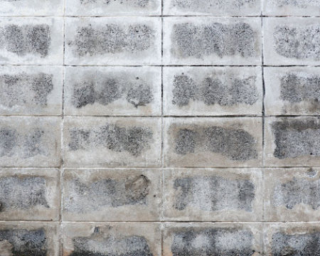 Professional installing outdoor floor tiles using VURA tile adhesive in suitable weather conditions.